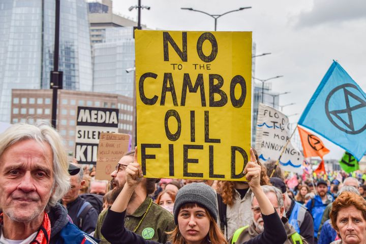 Extinction Rebellion protesters with a sign pushing back against the Cambo oil field