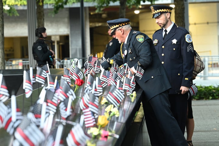 Retired Illinois Willow Springs Police Chief Sam Pulia and his nephew, Chicago Police Sgt. Daniel Pulia, place flags at the South Tower before the ceremony marking the 20th anniversary of the attacks.