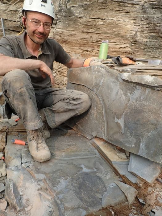 ティタノコリスの化石の上に座る、ジーン＝バーナード・キャロン氏