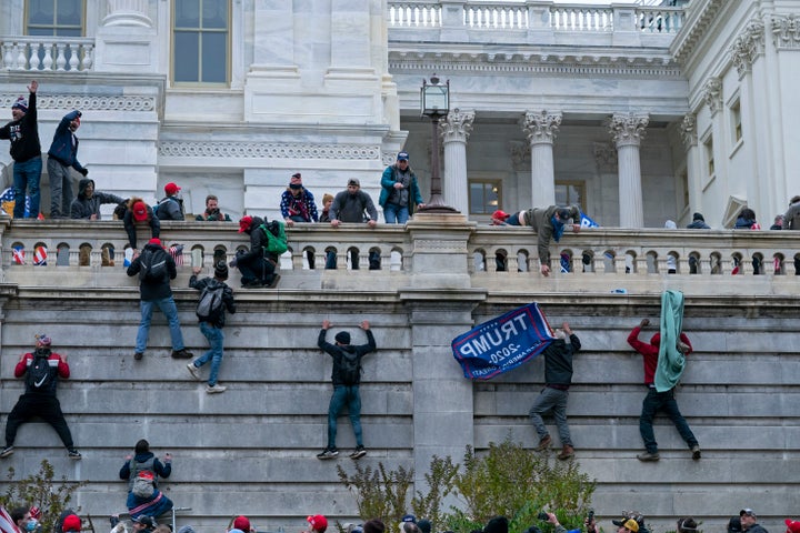 Rioters climb the west wall of the the U.S. Capitol in Washington during the Jan. 6 attack.
