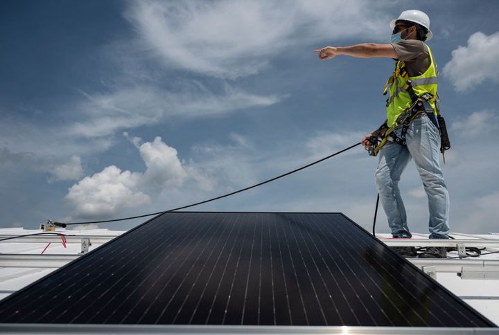An employee with Ipsun Solar installs solar panels on the roof of the Peace Lutheran Church in Alexandria, Virginia. Cable TV viewers in the area can expect to see new ads calling for a federal clean energy policy starting Monday morning.