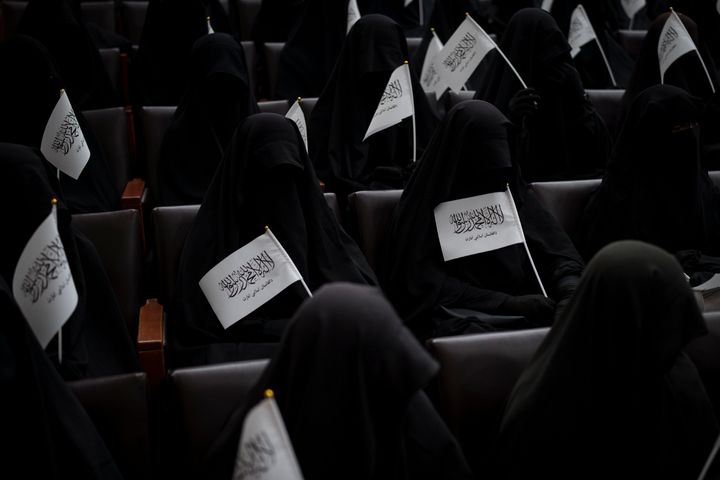 Women wave Taliban flags as they sit inside an auditorium at Kabul University's education center during a demonstration in support of the Taliban government in Kabul, Afghanistan, Saturday, Sept. 11, 2021. 