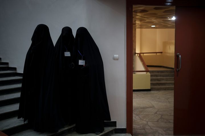 Women stand inside an auditorium at Kabul University's education center during a demonstration in support of the Taliban government.