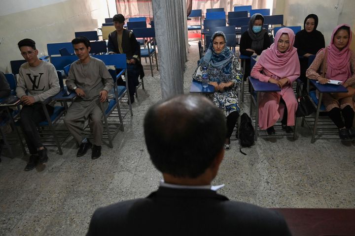 Students attend a class where male and female students are separated by a curtain at a private university in Kabul.