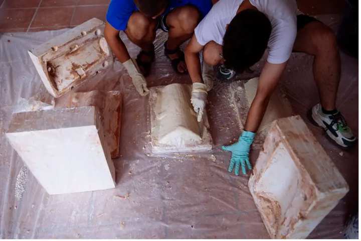 Dos jóvenes artistas crean unas tejas en los Encuentros del Arte de Genalguacil.