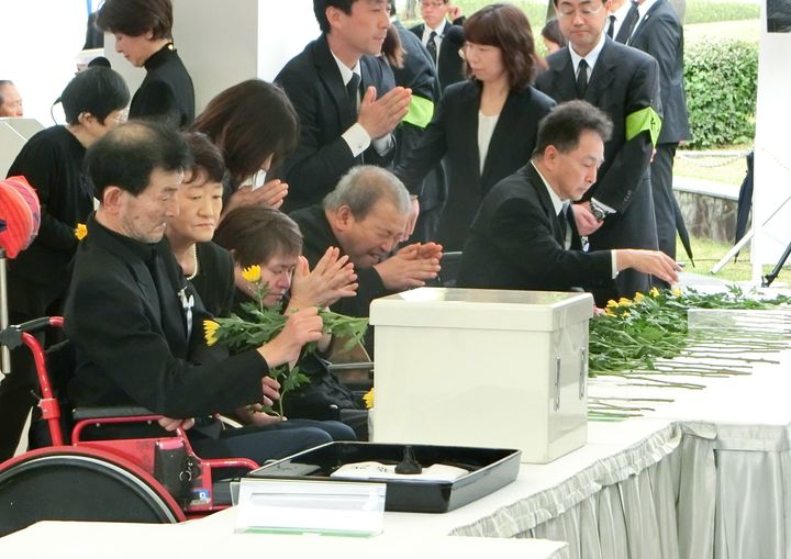 水俣病犠牲者慰霊式で、献花して手を合わせる水俣病患者ら＝2018年5月1日、熊本県水俣市