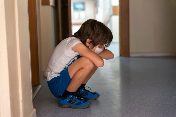 boy waiting sadly in hospital corridor