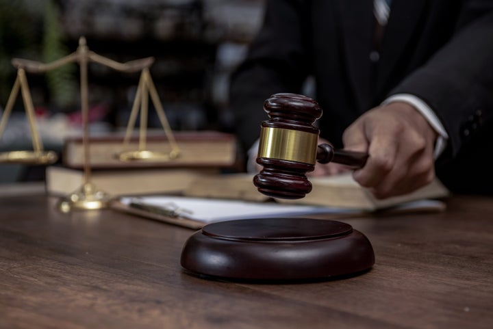 Man hand knocking a wooden judge gavel, law and auction concept.
