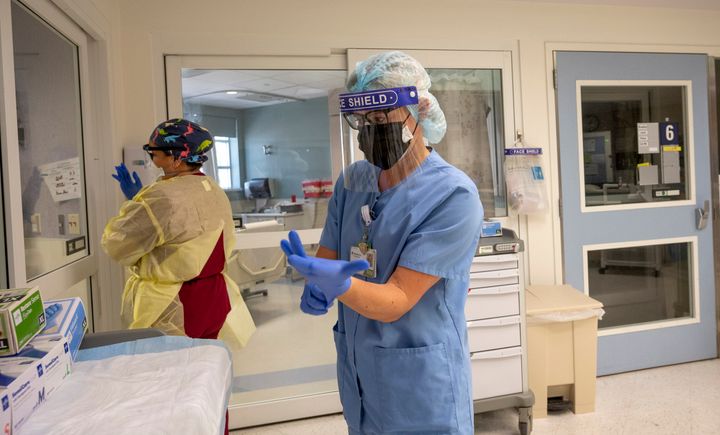 ICU nurses put on personal protective equipment in California, where COVID-19 cases are rising once again.