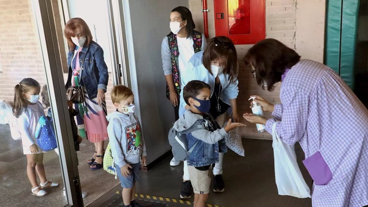 Menores entrando en un aula con mascarilla.