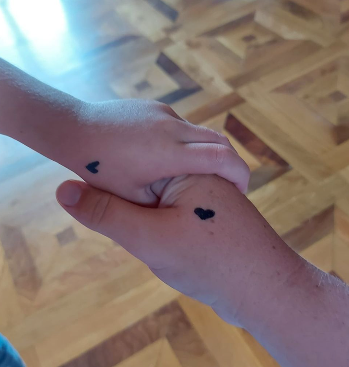 La mano de Sara Noguera y la de uno de sus hijos, con el recurso del corazón.