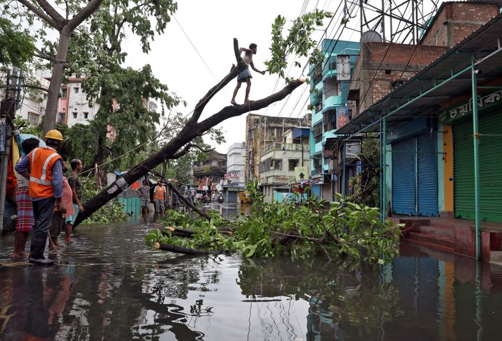 Ένας άνδρας κόβει κλαδιά από ένα ξεριζωμένο δέντρο μετά τον κυκλώνα Αμφαν, στην Καλκούτα της Ινδίας, 21 Μαΐου 2020. REUTERS/Rupak De Chowdhuri/Files