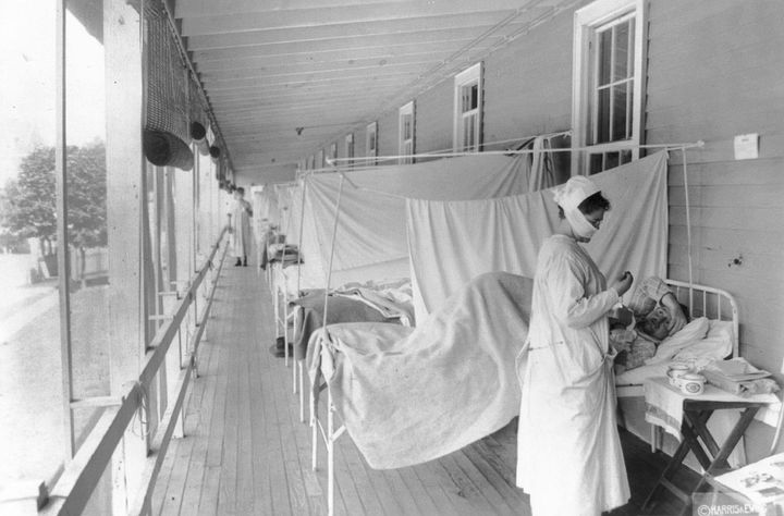 In this November 1918 photo made available by the Library of Congress, a nurse takes the pulse of a patient in the influenza 