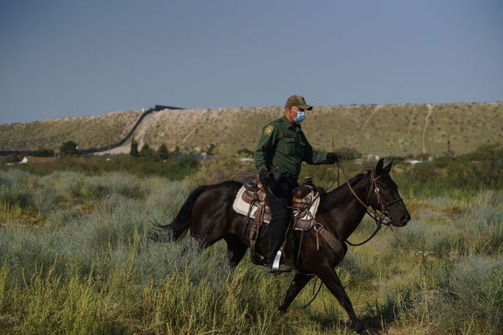 A US border patrol officer on horseback at the US-Mexico border in Sunland Park