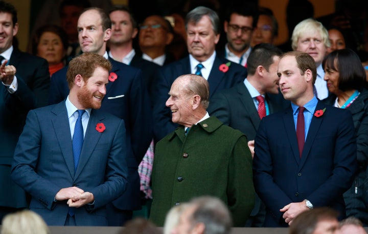 Los príncipes Guillermo y Harry, en la final de la Copa del mundo de rugby de 2015 junto a su abuelo.