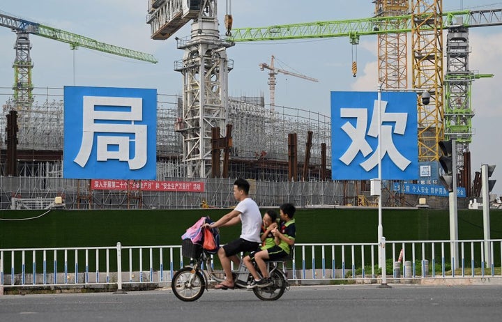 Un hombre pasa en bicicleta frente al estadio en construcción Guangzhou Evergrande, en Guangzhou (China), el pasado 17 de septiembre.