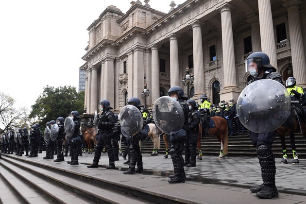 Riot police guard Victoria's Parliament House as construction workers and far right activists protest...