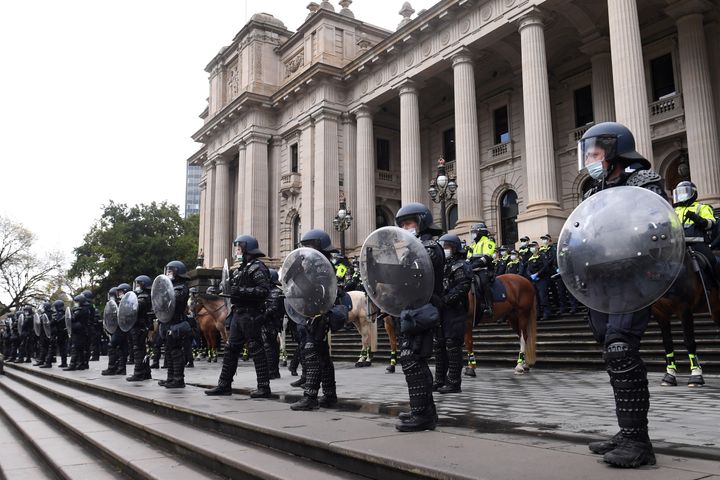 Riot police guard Victoria's Parliament House as construction workers and far right activists protest against Covid restrictions