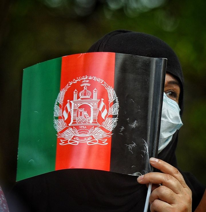 Γυναίκα από το Αφγανιστάν, κρατώντας τη σημαία της χώρας της, συμμετέχει σε συγκέντρωση κατά των Ταλιμπάν στο Νέο Δελχί της Ινδίας 