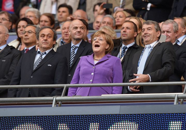 Με μοβ συνολάκι ανάμεσα σε μαυροντυμένους άντρες στον τελικό της Champions League.