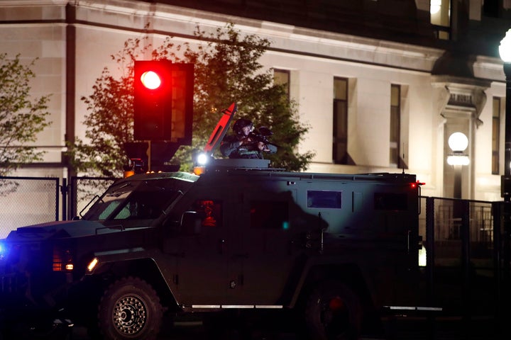 A member of the sheriff's department aims an anti-riot weapon from an armored vehicle during demonstrations against the police shooting of Jacob Blake in Kenosha, Wisconsin, on Aug. 25, 2020.