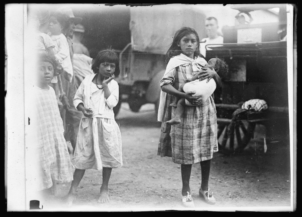 A young woman who survived the flood holds a baby after the disaster that killed dozens in her community.