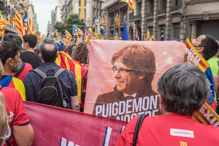 Protester is seen with a flag with the face of Carles Puigdemont, former president of the Generalitat of Catalonia. On the day that the traditional Diada de Catalunya 2021, National Day of Catalonia is celebrated, a large demonstration for independence with more than 400,000 people has been held in Barcelona. Some protesters at the end of the demonstration have had conflict with the police. (Photo by DAX Images/NurPhoto via Getty Images)