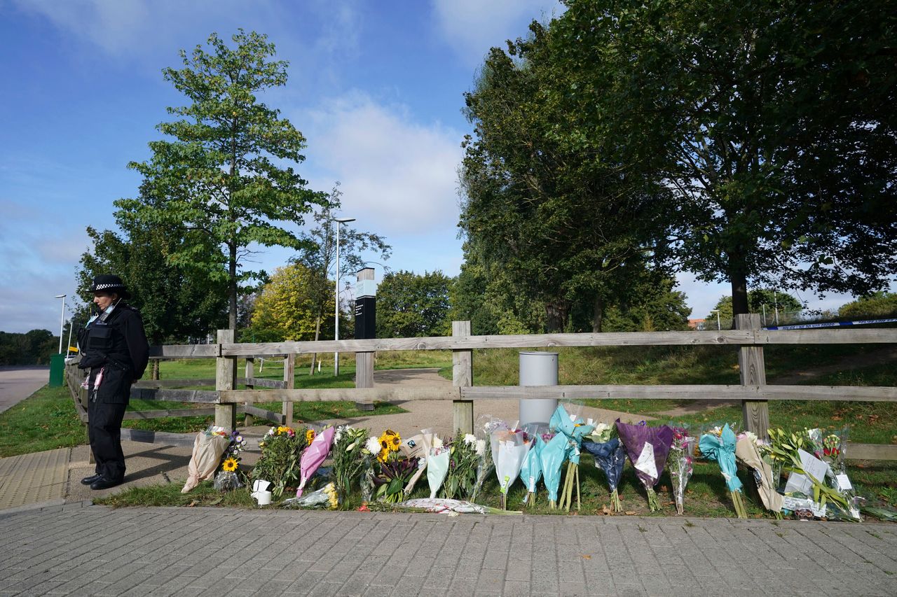 A police officer stands by floral tributes at Cator Park in Kidbrooke, near to the area where the body of Sabina Nessa was found.