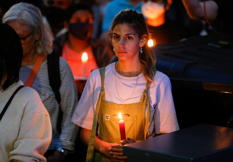 A person holds a candle during a vigil in memory of Sabina