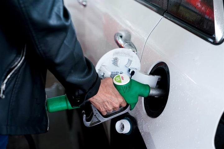 Una mujer pone gasolina a su vehículo en una gasolinera.