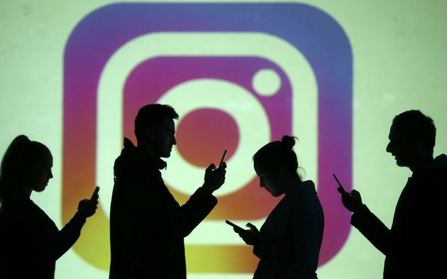 Des silhouettes devant un écran projettant le logo d'Instagram, le 28 mars 2018 (photo