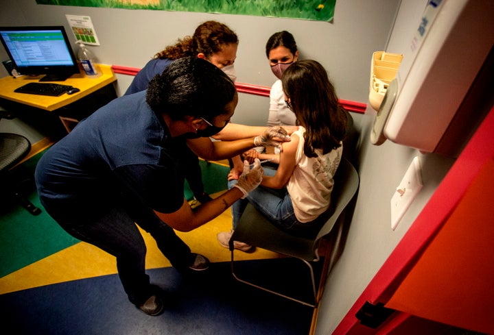 A middle school student receives her first coronavirus vaccination on May 12, 2021, in Decatur, Georgia. Hundreds of children, ages 12 to 15, received the Pfizer vaccine at the DeKalb Pediatric Center just days after it was approved for use within their age group.