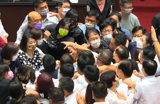Οι βουλευτές της αντιπολίτευσης ενώ σπάνε τον προστατευτικό κλοιό γύρω από τον πρωθυπουργό, Σου Τσενγκ Τσανγκ.