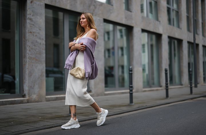 Η Michi Brandl φοράει μπεζ πλεκτό φόρεμα LeGer, μπεζ δερμάτινη τσάντα Bottega Veneta, λιλά κουκούλα Zara και πάνινα παπούτσια από τα στούντιο της Κοπεγχάγης