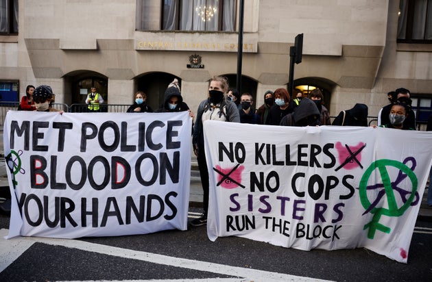 Demonstrators hold banners as they await the sentencing of British police officer Wayne Couzens for the...