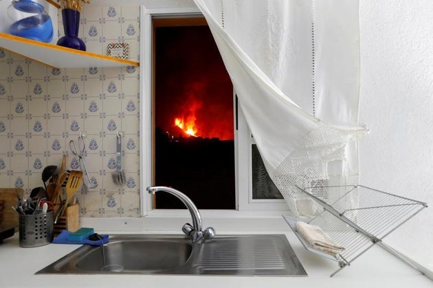 Lava is seen through the window of a kitchen from El Paso following a volcanic eruption on the Canary...
