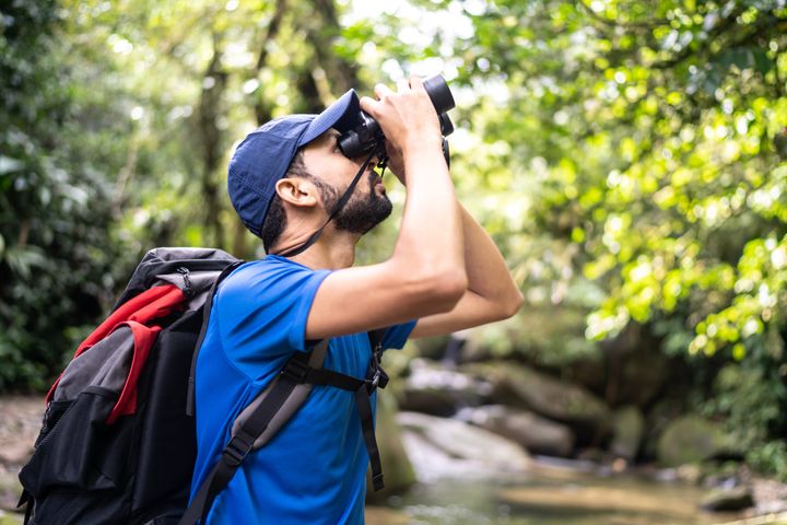 Man using binoculars in a forest
