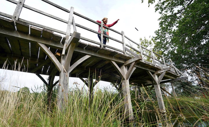 Silke Lohmann of Summers Place Auctions stands on the original Poohsticks Bridge from Ashdown Forest, featured in A.A. Milne's Winnie the Pooh books and E.H. Shepard's illustrations, near its original location in Tonbridge, Kent, England, Thursday, Sept. 30.