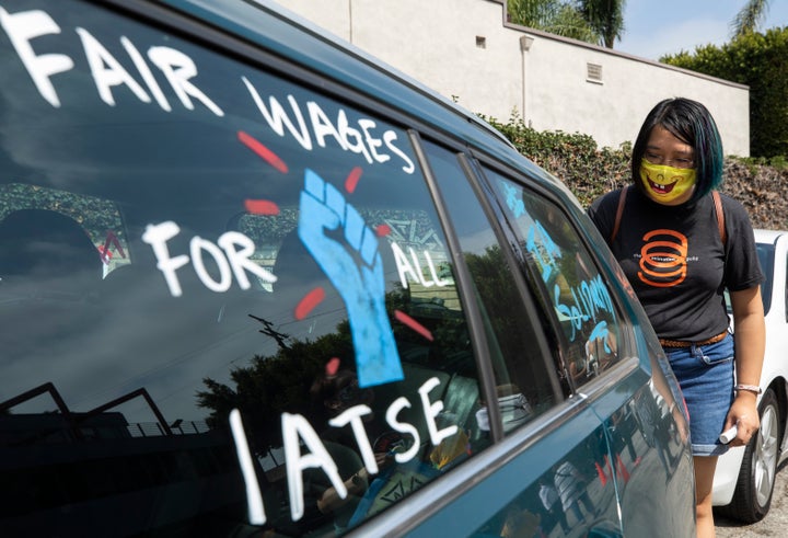 A strike by IATSE members would be the largest the U.S. private sector has seen since 2007. Here, a worker paints pro-union images on cars at a rally in Los Angeles in September.