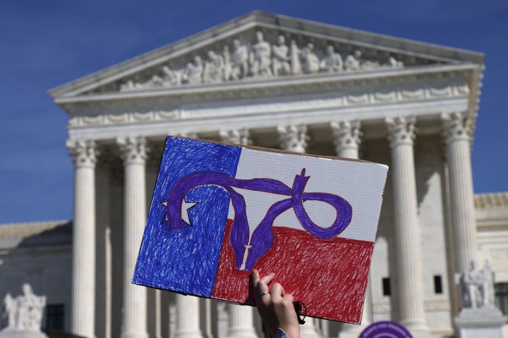 An activist holds up a sign.