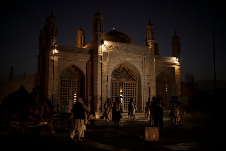 Taliban fighters walk at the entrance of the Eidgah Mosque after an explosion in Kabul, Afghanistan, Sunday, Oct. 3, 2021. A bomb exploded in the entrance of the mosque in the Afghan capital on Sunday leaving a "number of civilians dead," a Taliban spokesman said.