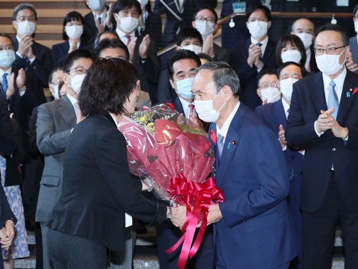 内閣を総辞職し、花束を手渡される菅義偉首相（手前右）＝2021年10月4日、東京・永田町