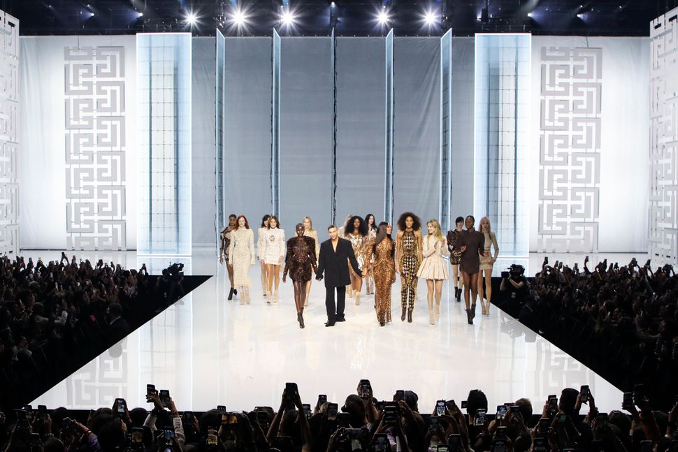 Ο Ολιβιέ Ρουστέινγκ, (κέντρο), δέχεται το χειροκρότημα καθώς περπατά με μοντέλα στο τέλος της επίδειξης μόδας του οίκου Balmain με το βλέμμα στην άνοιξη και το καλοκαίρι του 2022 στο Παρίσι. 