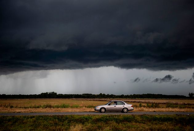 Une voiture roule sous un nuage de pluie menaçant de la tempête tropicale Marco près de Lake Charles, en Louisiane, le 25 août 2020.