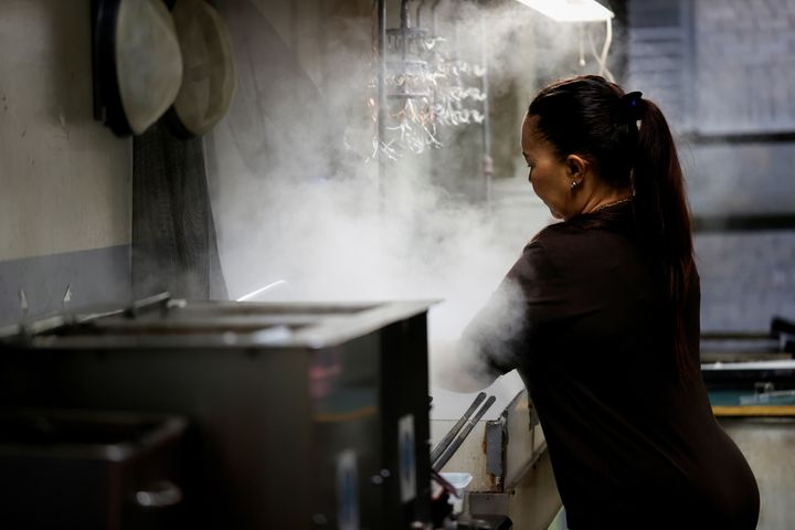 Εργάτρια κοσμημάτων εργάζεται σε μηχανή καθαρισμού με ατμό σε εργαστήριο στο τμήμα σχεδιασμού κοσμημάτων