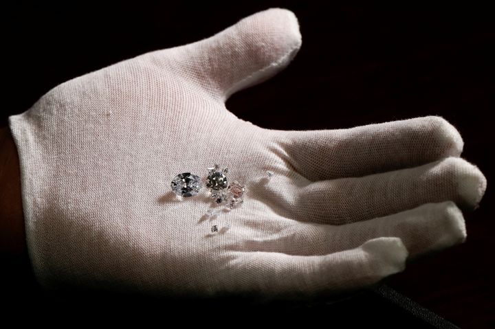 Ένας υπάλληλος που φορά ένα λευκό γάντι εμφανίζει διάφορα διαμάντια Αιθέρα από συλλεγμένο CO2 στην εγκατάσταση σχεδιασμού κοσμημάτων