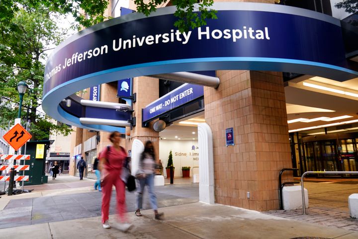 Pedestrians walk past Thomas Jefferson University Hospital in Philadelphia, on Monday. Police said a nurse fatally shot his co-worker at the hospital and was later captured after a gunfight with police that wounded two officers.