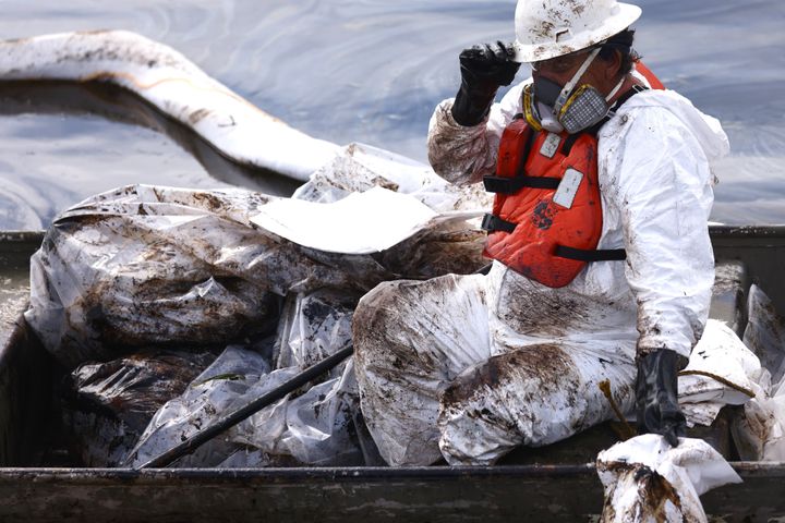 A worker in a protective suit cleans oil Monday in the Talbert Marsh wetlands after a 126,000-gallon oil spill off Huntington Beach, California. 