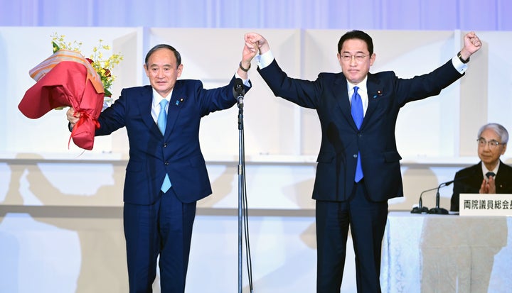 自民党総裁選挙を終え、万歳する菅義偉首相（左）と岸田文雄新総裁＝9月29日、東京都港区、代表撮影