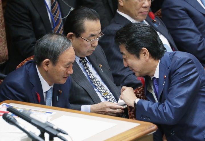 2019年10月15日、参議院予算委員会で当時の菅義偉官房長官（左）と話す安倍晋三首相（当時）＝国会内